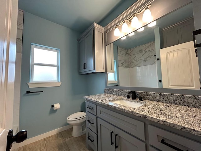 bathroom featuring vanity, walk in shower, toilet, and baseboards