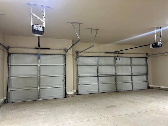 garage with baseboards and a garage door opener