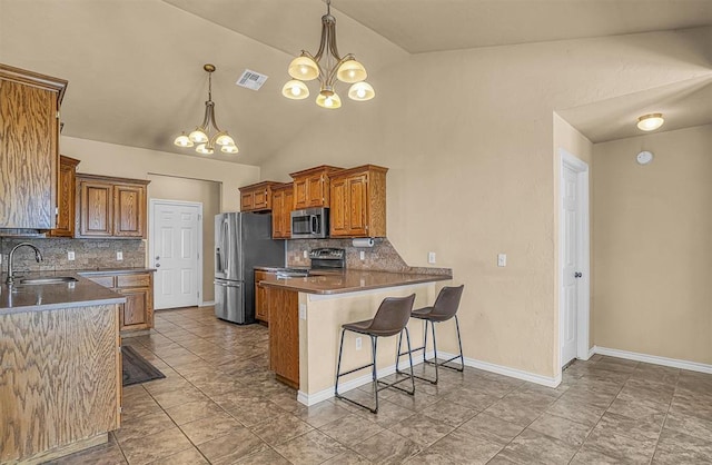 kitchen featuring visible vents, a peninsula, stainless steel appliances, a chandelier, and a sink