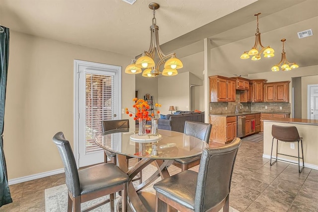 dining space featuring a chandelier, vaulted ceiling, visible vents, and baseboards