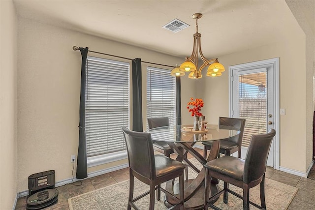 dining area with baseboards, visible vents, and an inviting chandelier