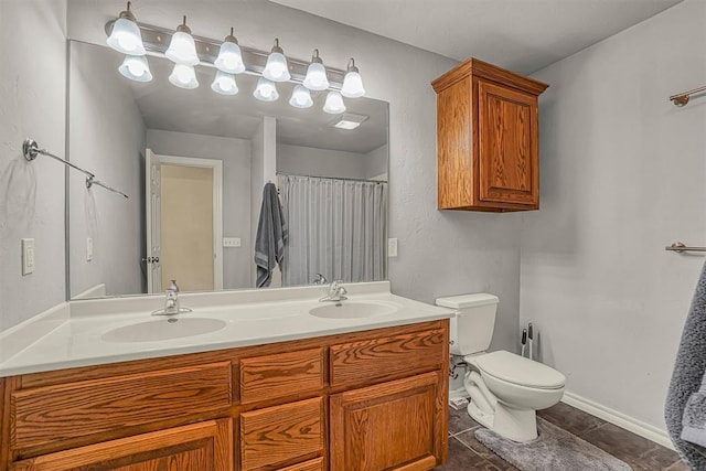 bathroom featuring toilet, tile patterned flooring, double vanity, and a sink