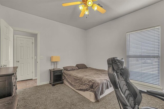 bedroom featuring light colored carpet, ceiling fan, and baseboards