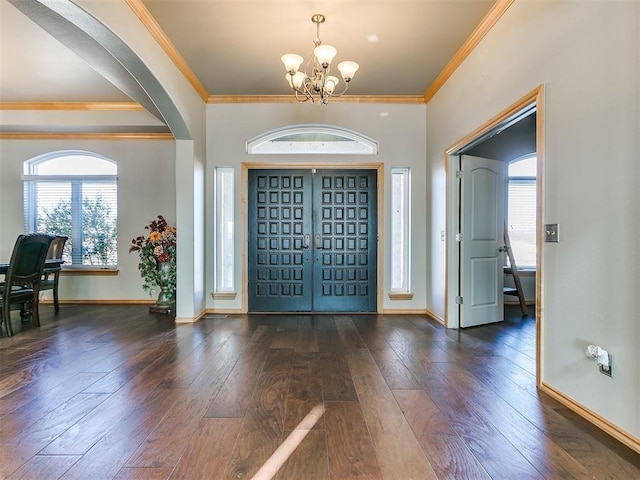 foyer with a notable chandelier, baseboards, wood finished floors, and ornamental molding