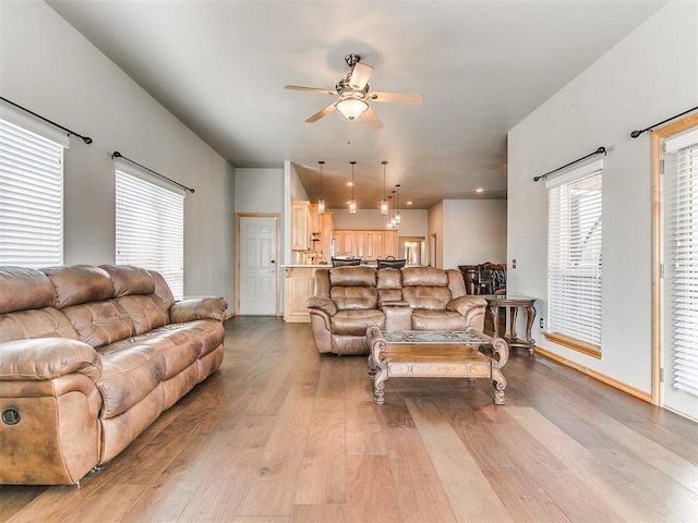 living room with ceiling fan and light wood-style floors