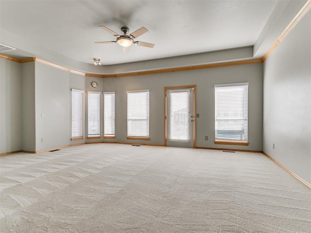 spare room with carpet floors, baseboards, visible vents, and a ceiling fan