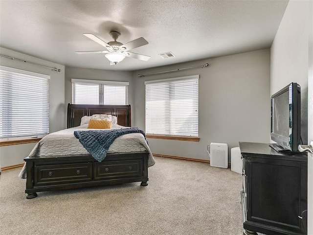 bedroom with ceiling fan, baseboards, visible vents, and light colored carpet