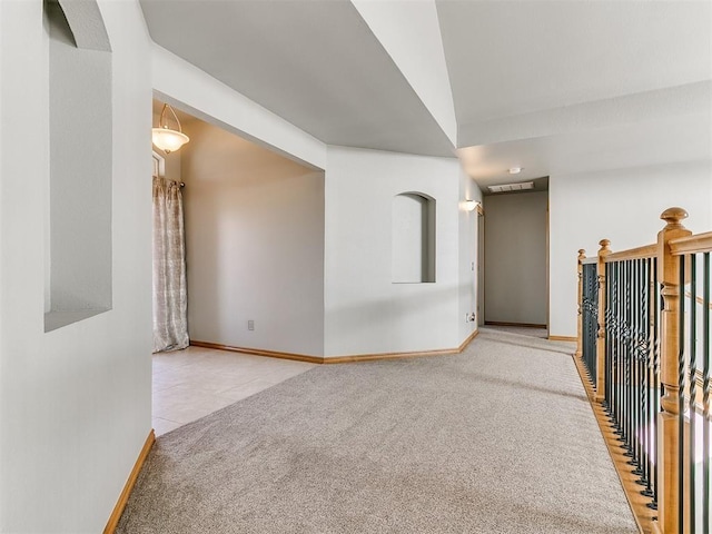 carpeted empty room with baseboards and tile patterned floors