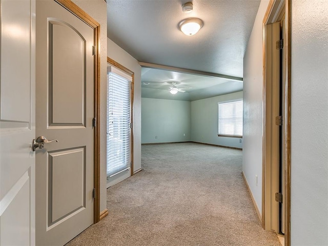 spare room with baseboards and light colored carpet