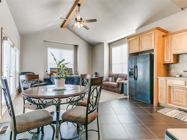 dining area with visible vents, vaulted ceiling with beams, dark tile patterned floors, and ceiling fan