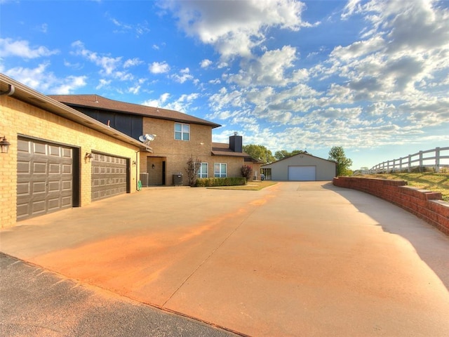 view of front of house featuring a garage, fence, and an outdoor structure