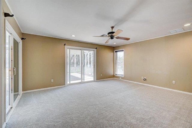 unfurnished room featuring carpet, visible vents, baseboards, ceiling fan, and crown molding