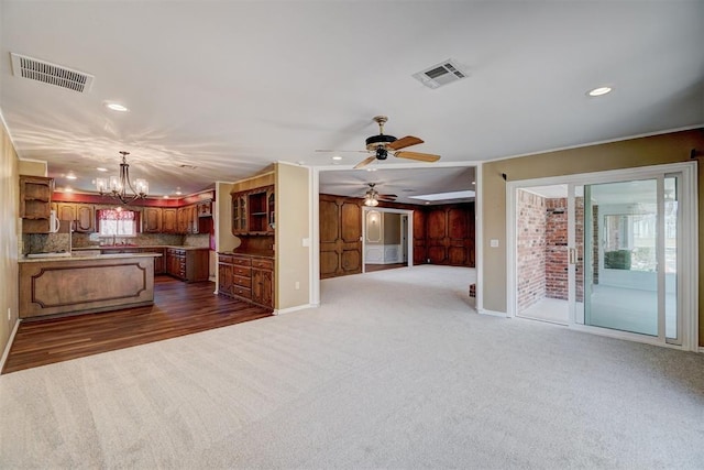 unfurnished living room featuring recessed lighting, visible vents, dark carpet, and ceiling fan with notable chandelier