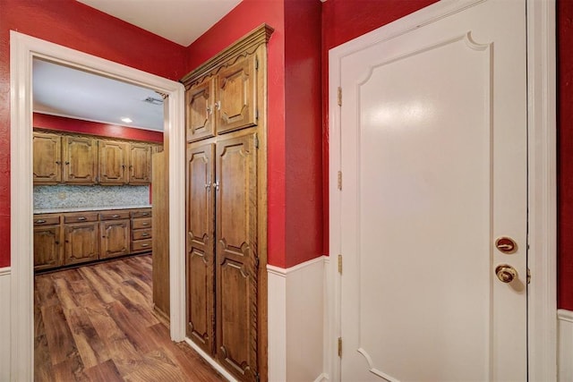 hall with visible vents and wood finished floors