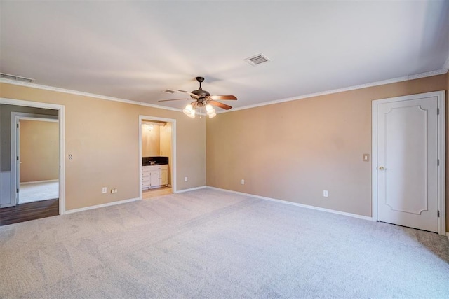 unfurnished bedroom with baseboards, light colored carpet, visible vents, and ornamental molding