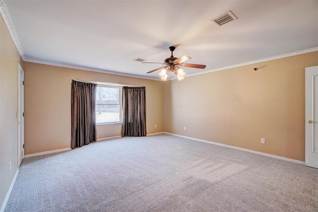 empty room featuring crown molding, baseboards, visible vents, and light carpet