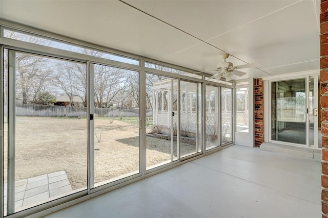 unfurnished sunroom featuring a healthy amount of sunlight and a ceiling fan