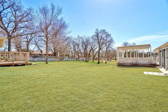 view of yard with a wooden deck and fence