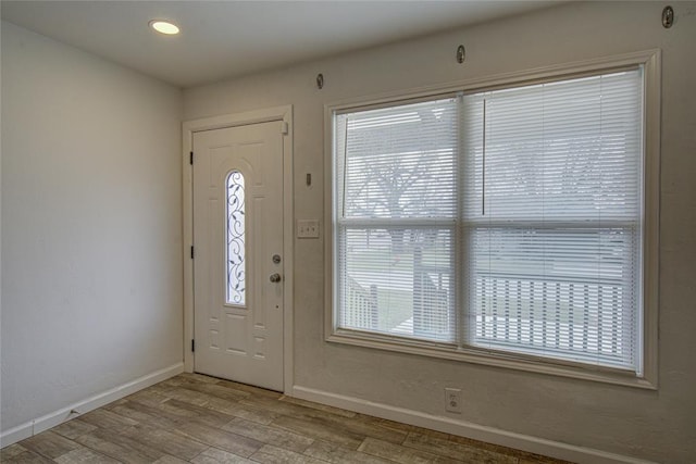 foyer featuring recessed lighting, plenty of natural light, wood finished floors, and baseboards