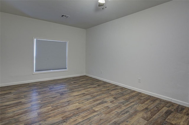 empty room with visible vents, dark wood finished floors, baseboards, and ceiling fan