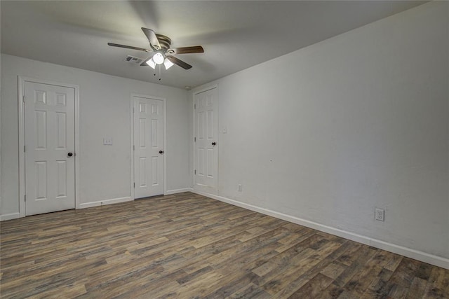 spare room with a ceiling fan, baseboards, visible vents, and wood finished floors