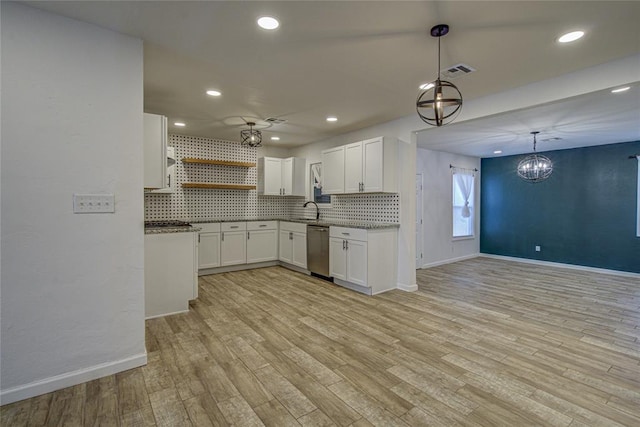 kitchen with open shelves, visible vents, decorative backsplash, stainless steel dishwasher, and a sink