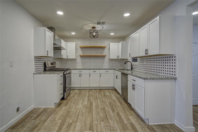 kitchen featuring light wood-style flooring, stainless steel appliances, visible vents, light stone countertops, and open shelves