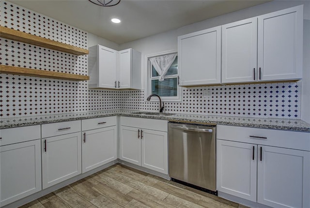 kitchen with a sink, stainless steel dishwasher, light wood-type flooring, backsplash, and open shelves