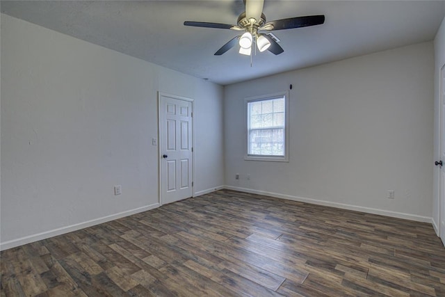 unfurnished room with a ceiling fan, dark wood finished floors, and baseboards