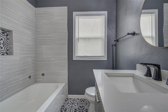 full bathroom featuring toilet, vanity, baseboards, a bath, and tile patterned floors