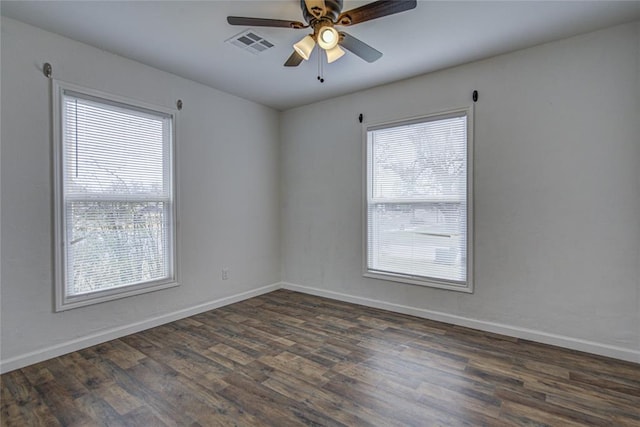 unfurnished room with ceiling fan, dark wood-type flooring, visible vents, and baseboards