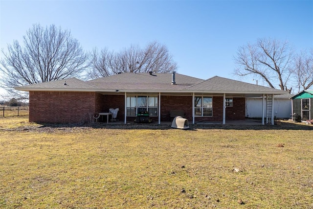 back of house featuring a patio area, a yard, brick siding, and fence