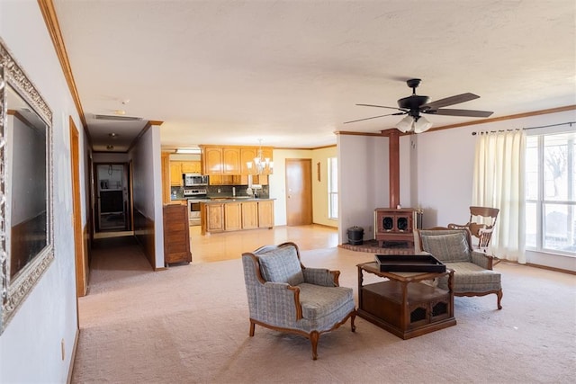 living area featuring a wood stove, visible vents, ornamental molding, and light colored carpet