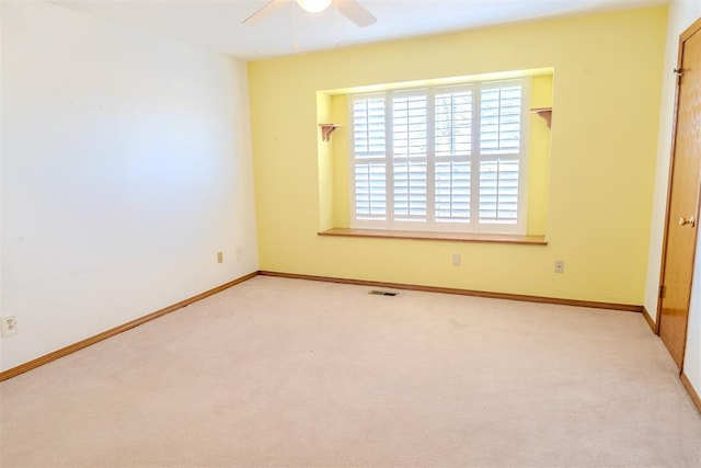 spare room featuring ceiling fan, carpet flooring, visible vents, and baseboards