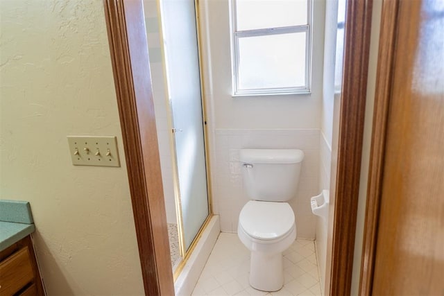 full bath with tile walls, vanity, toilet, and a shower stall