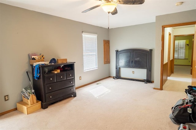 bedroom with a ceiling fan, light carpet, and baseboards