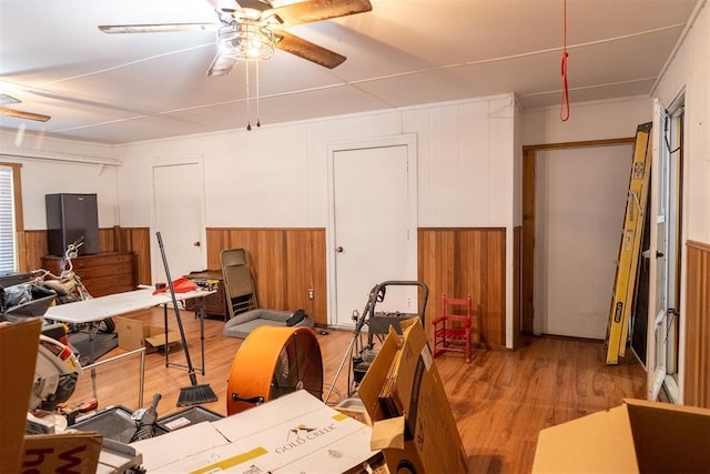 interior space featuring ceiling fan and wooden walls