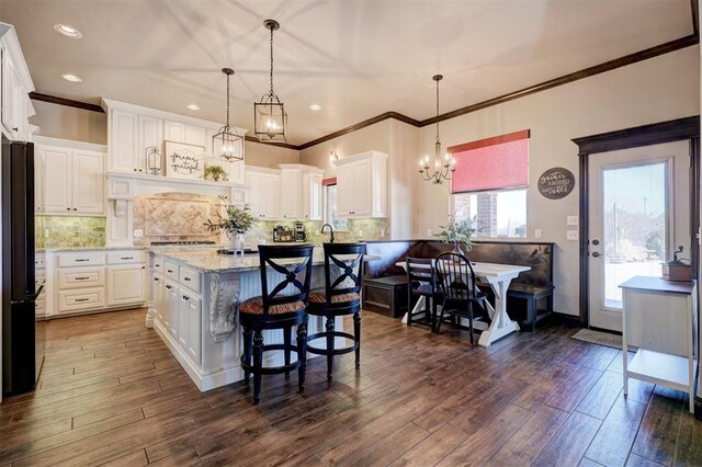 kitchen with dark wood finished floors, freestanding refrigerator, and white cabinetry