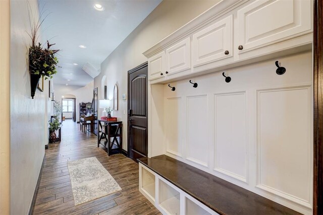 mudroom featuring arched walkways, dark wood-style flooring, and recessed lighting