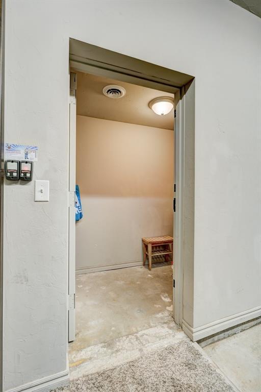 corridor with unfinished concrete flooring and visible vents