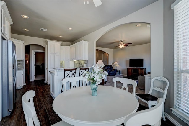 dining room with arched walkways, ceiling fan, dark wood finished floors, and recessed lighting