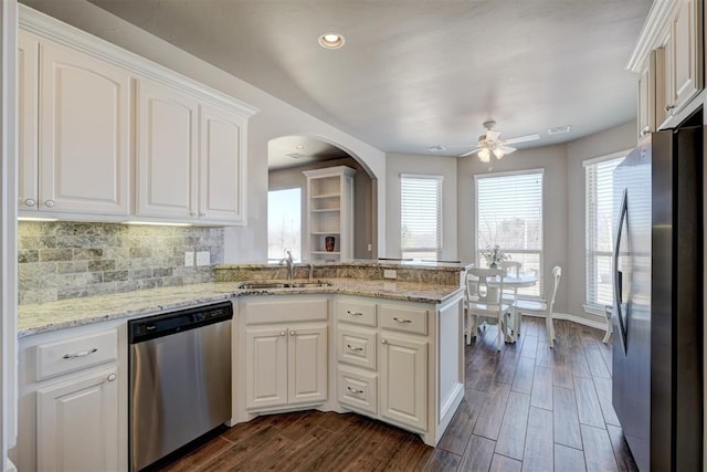 kitchen featuring stainless steel appliances, wood finish floors, white cabinetry, and a sink