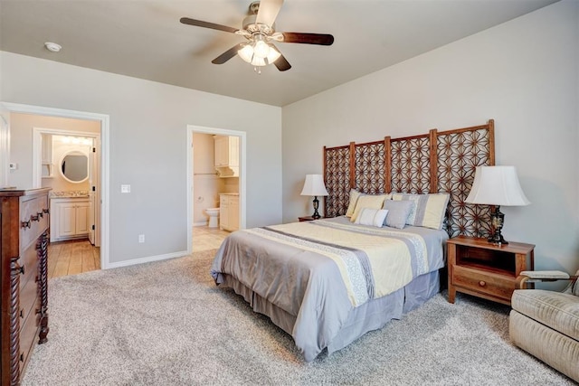 bedroom featuring ensuite bathroom, ceiling fan, light carpet, and baseboards