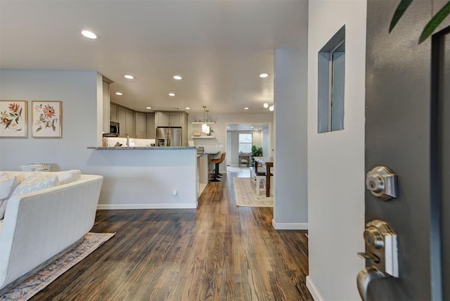 interior space with baseboards, dark wood-type flooring, and recessed lighting