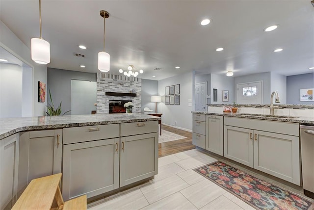 kitchen with recessed lighting, a sink, open floor plan, dishwasher, and decorative light fixtures