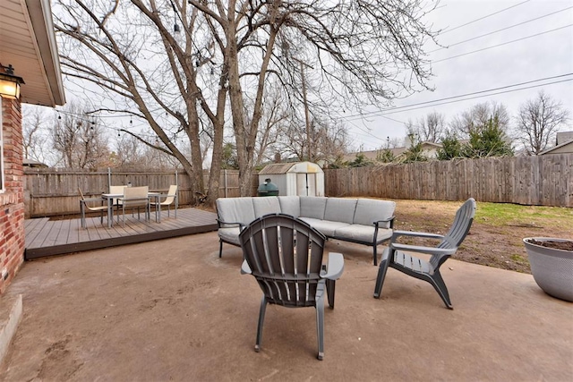 view of patio / terrace featuring an outbuilding, a deck, a fenced backyard, outdoor lounge area, and a storage unit