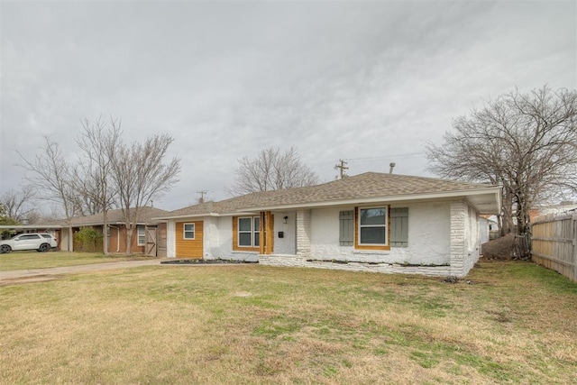 view of front of property with a shingled roof, a front yard, and fence