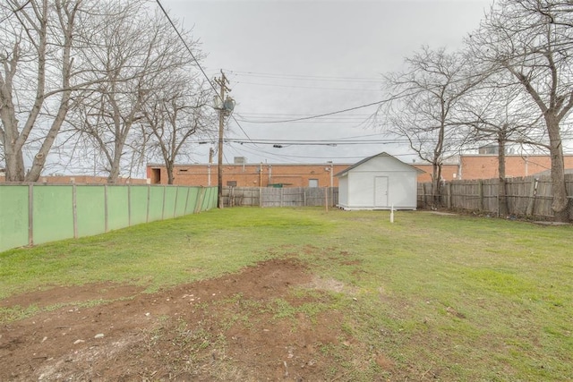 view of yard with an outbuilding, a fenced backyard, and a storage shed