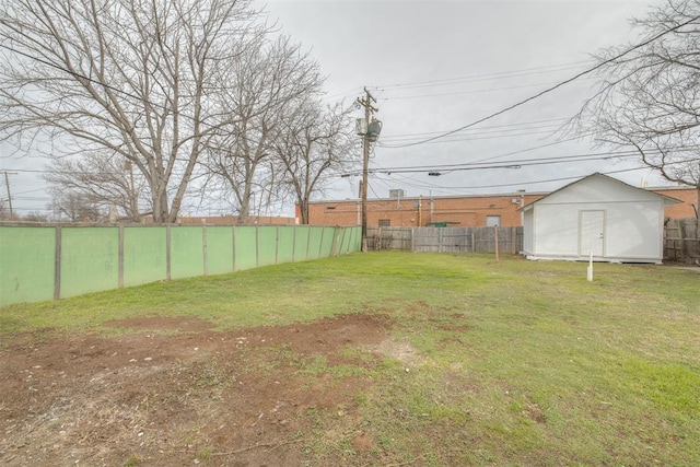 view of yard featuring an outbuilding, fence, and a storage unit