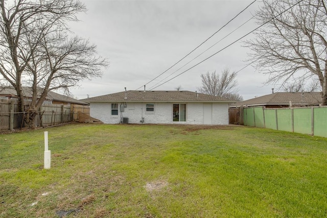 back of property featuring central AC unit, a lawn, and a fenced backyard